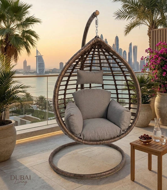 Hanging egg chair with woven frame and gray seat cushion, suspended by chain