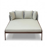Double daybed with off-white cushions and wood-finish aluminum frame.